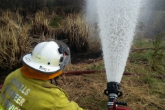 Crews working a ground monitor at a peat fire